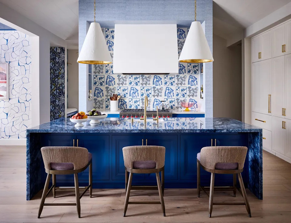 Modern kitchen with blue cabinetry and decorative tiles.