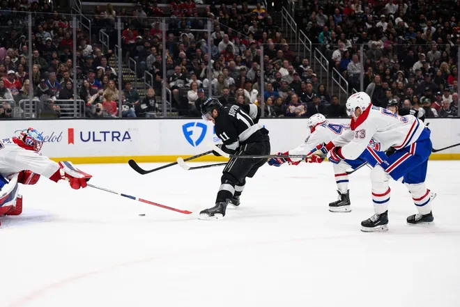 Mar 7, 2026; Los Angeles, California, USA; Los Angeles Kings center Anze Kopitar (11) looks to shoot the puck while under pressure from Montréal Canadiens defensemen Lane Hutson (48) and Noah Dobson (53) during the second period at Crypto.com Arena.