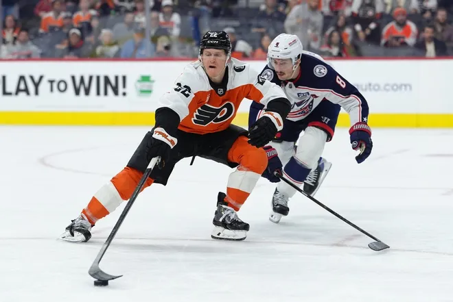 Mar 24, 2026; Philadelphia, Pennsylvania, USA; Philadelphia Flyers center Christian Dvorak (22) loses control of the puck against Columbus Blue Jackets defenseman Zach Werenski (8) in the third period at Xfinity Mobile Arena.