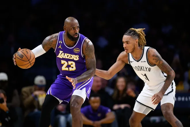 Mar 27, 2026; Los Angeles, California, USA; Los Angeles Lakers forward LeBron James (23) dribbles against Brooklyn Nets forward Noah Clowney (21) during the first half at Crypto.com Arena.