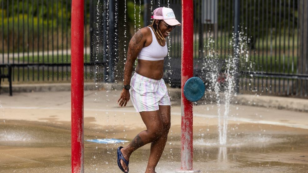 Samara Balans, 41, of Bronzeville, cools off in the water feature at River Park on the Northwest Side as temperatures across Chicago hit a high of 97 degrees, Tuesday, Aug. 27, 2024. (Ashlee Rezin/Chicago Sun-Times via AP)