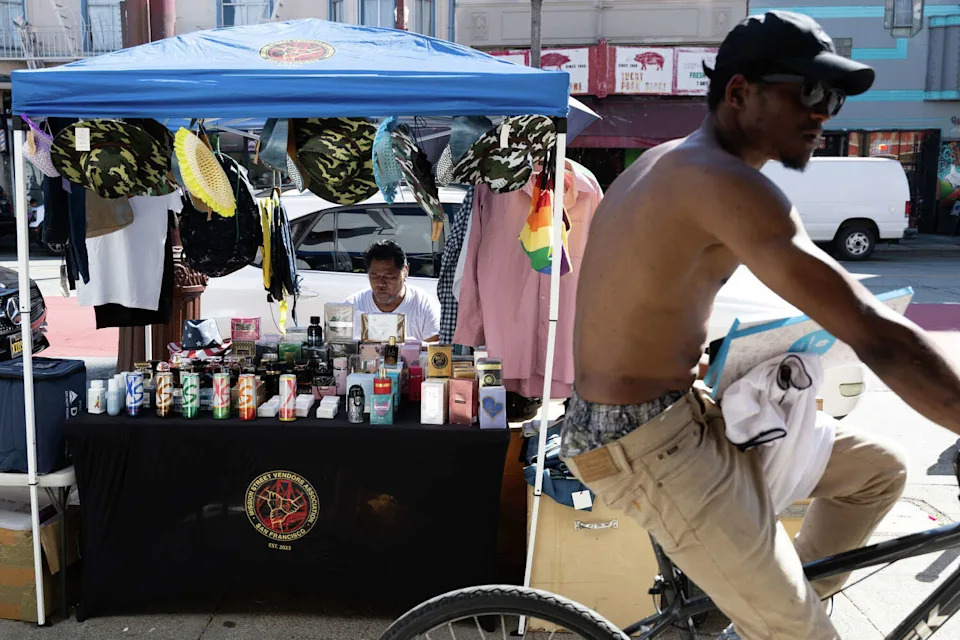 A bicyclist rides past Juan Mendoza along Mission Street in San Francisco on Friday, March 20, 2026. The Bay Area is experiencing a record breaking heat wave. (Benjamin Fanjoy/For the S.F. Chronicle)