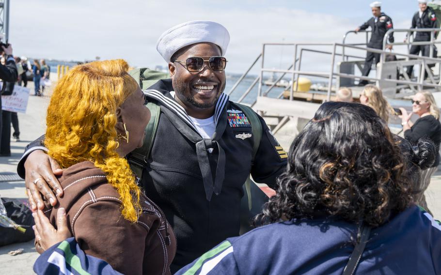 A sailor smiles while looks at his family.