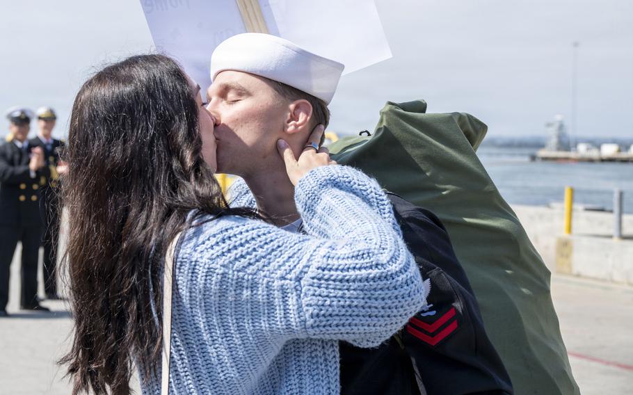 A sailor kisses a woman.