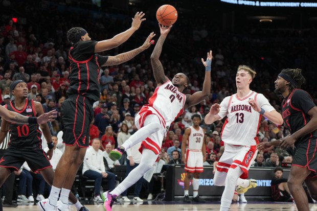 Arizona guard Jaden Bradley (0) shoots against San Diego State guard Taj Degourville, center left, during the second half of an NCAA college basketball game, Saturday, Dec. 20, 2025, in Phoenix. (AP Photo/Rick Scuteri)