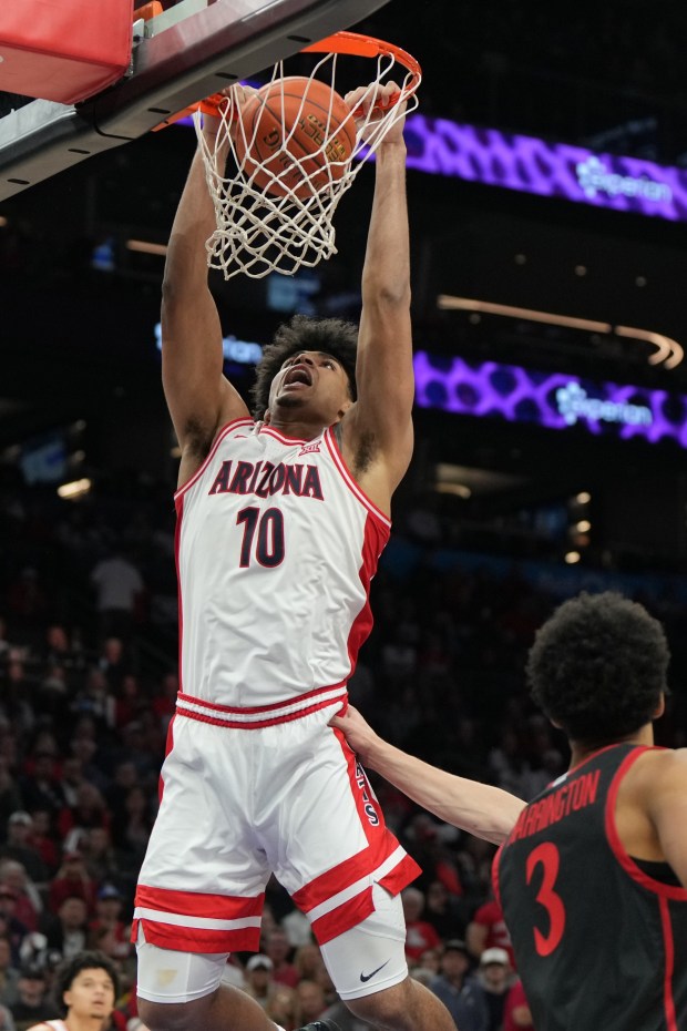 Arizona forward Koa Peat (10) dunks over San Diego State guard Elzie Harrington (3) during the second half of an NCAA college basketball game, Saturday, Dec. 20, 2025, in Phoenix. (AP Photo/Rick Scuteri)