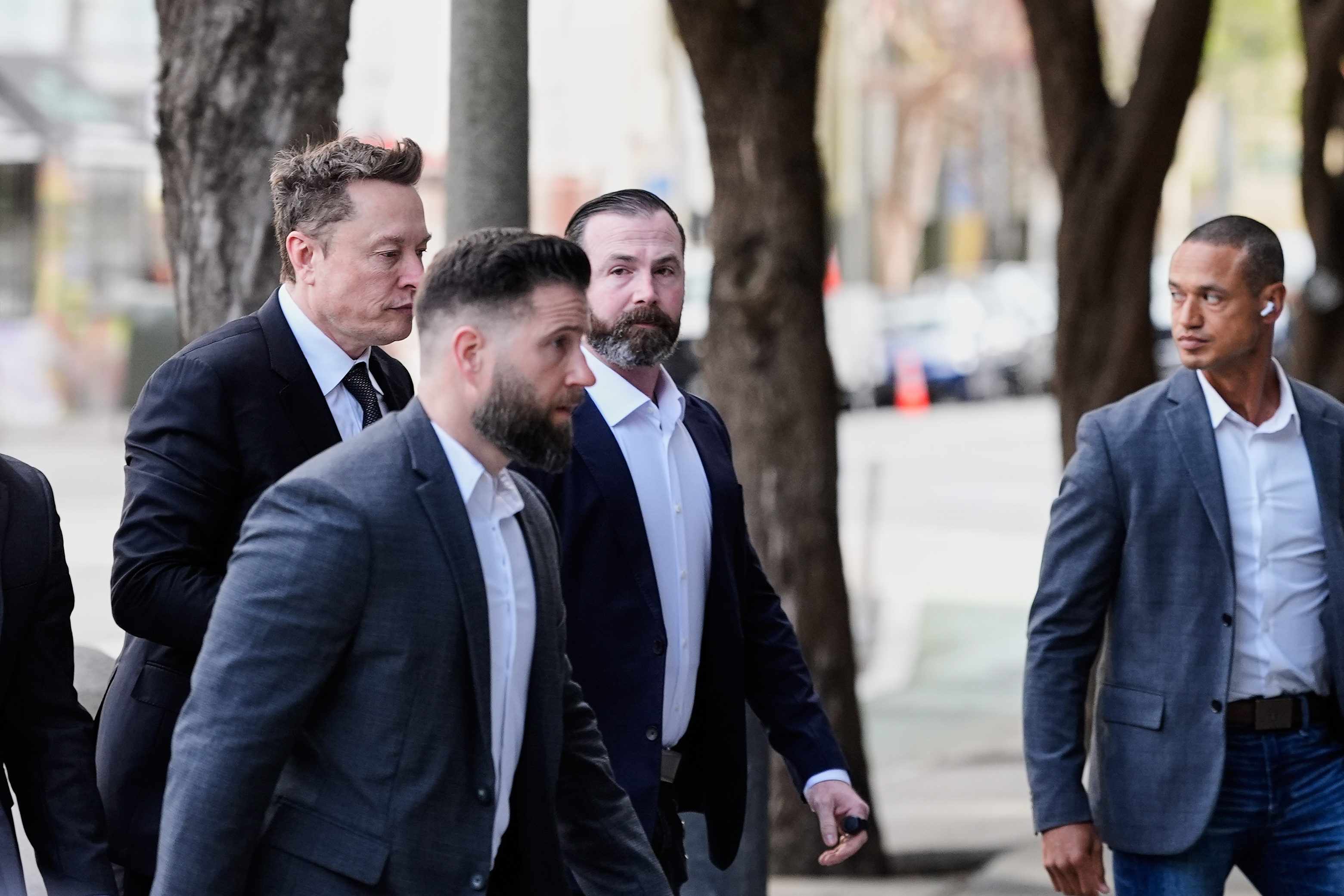 Elon Musk, left, arrives for a Twitter shareholder trial at...