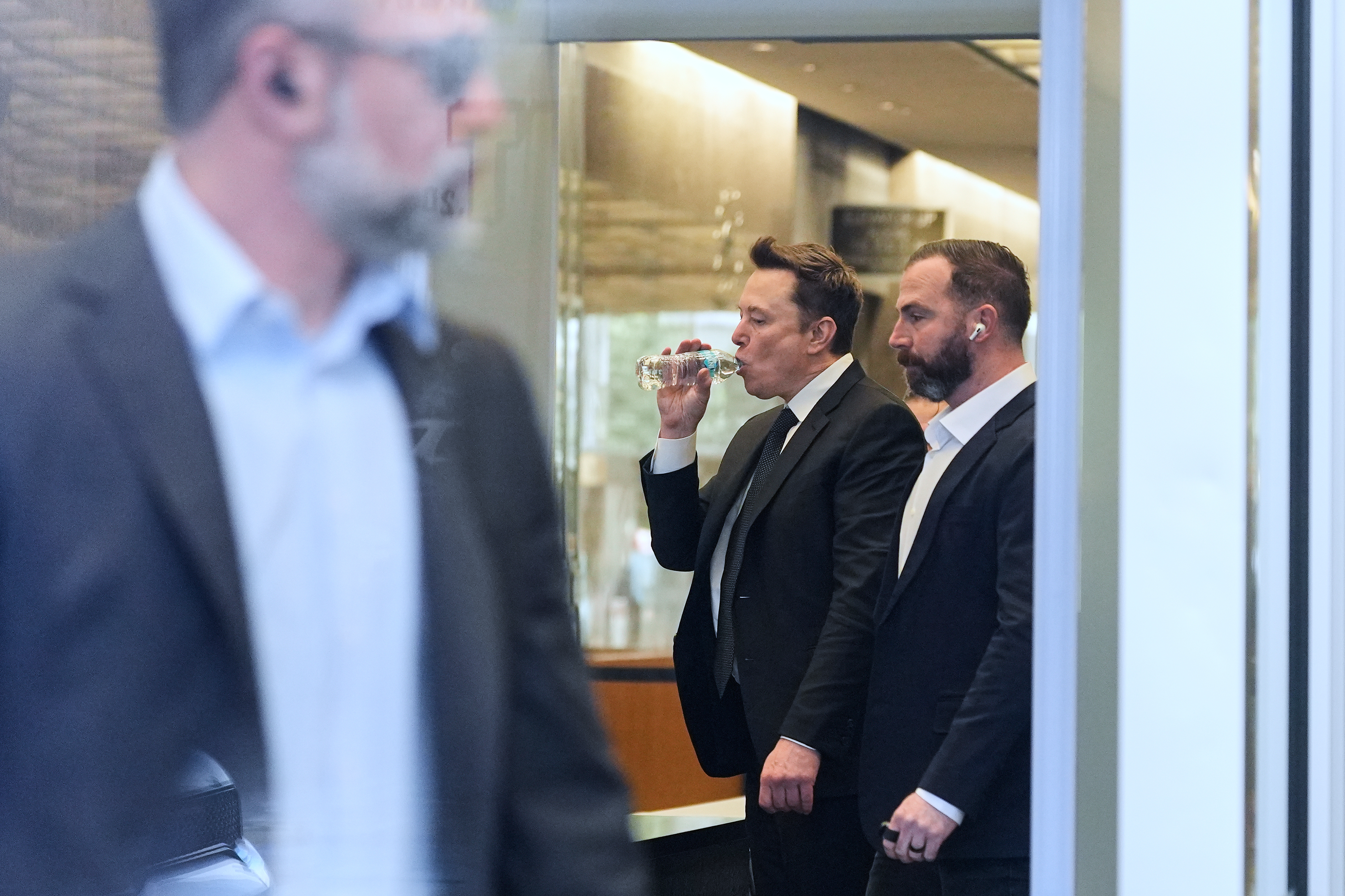 Elon Musk, center, arrives for a Twitter shareholder trial at...