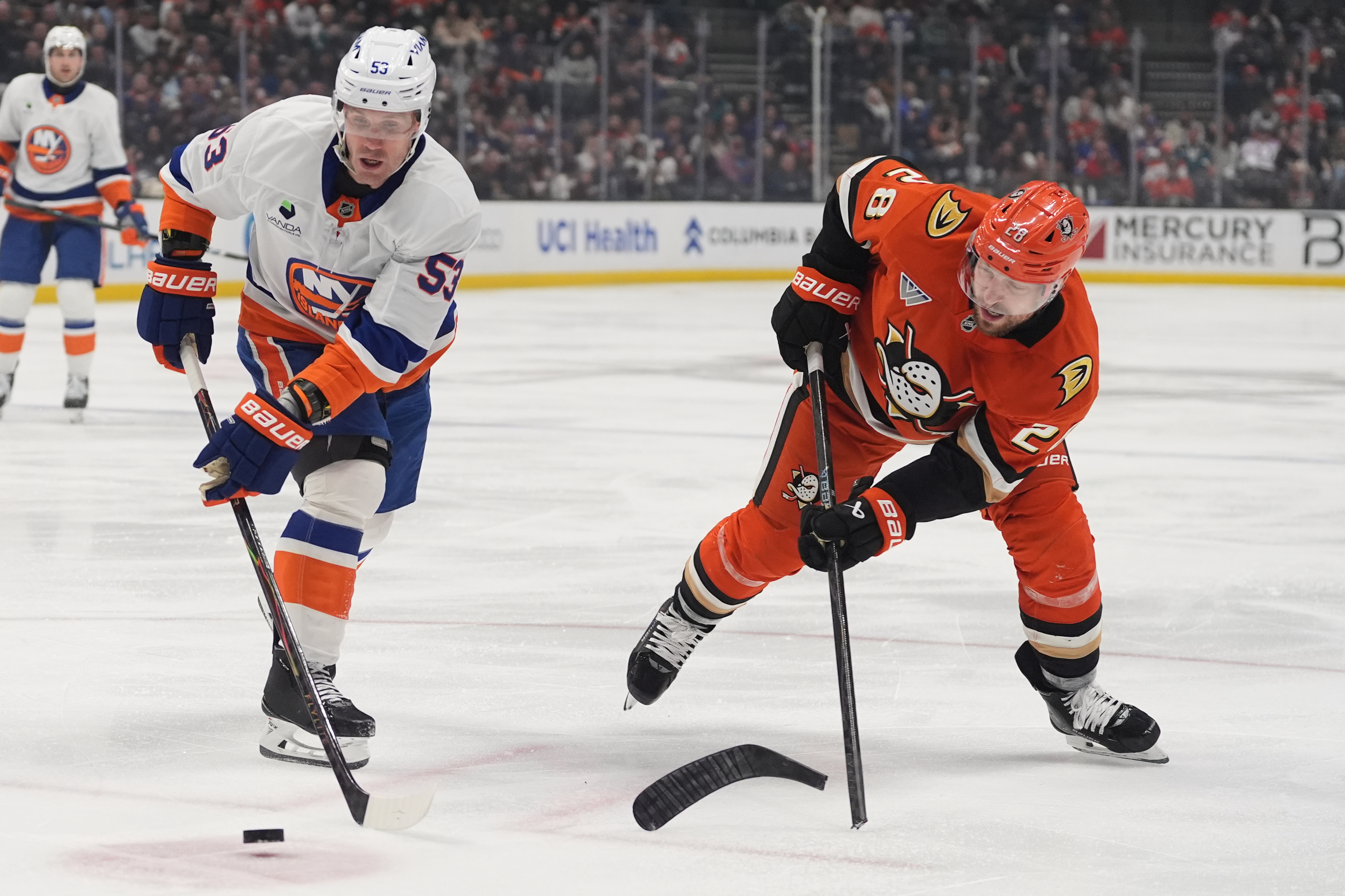 New York Islanders center Casey Cizikas, left, tries to clear...