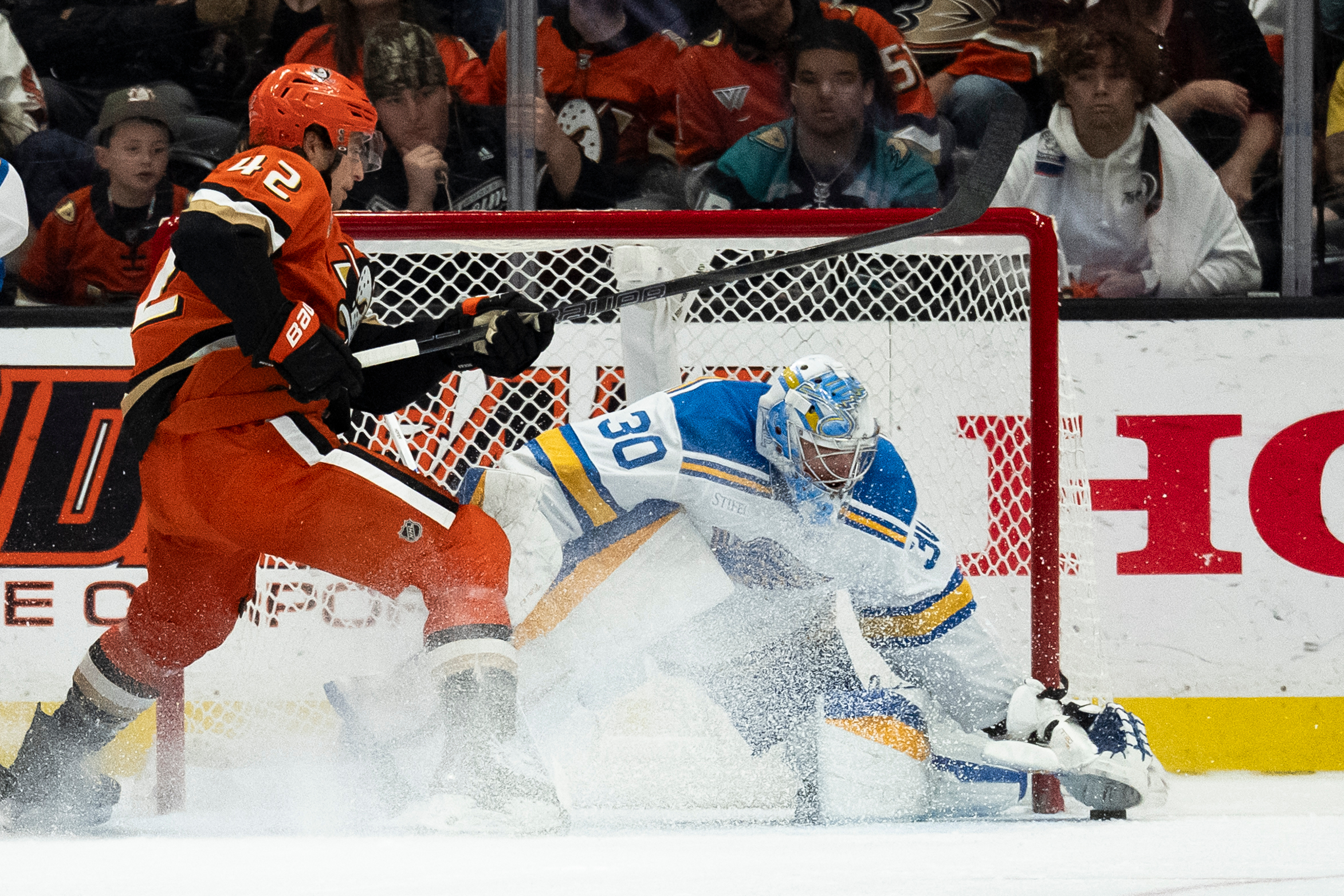 St. Louis Blues goaltender Joel Hofer, right, freezes the puck...