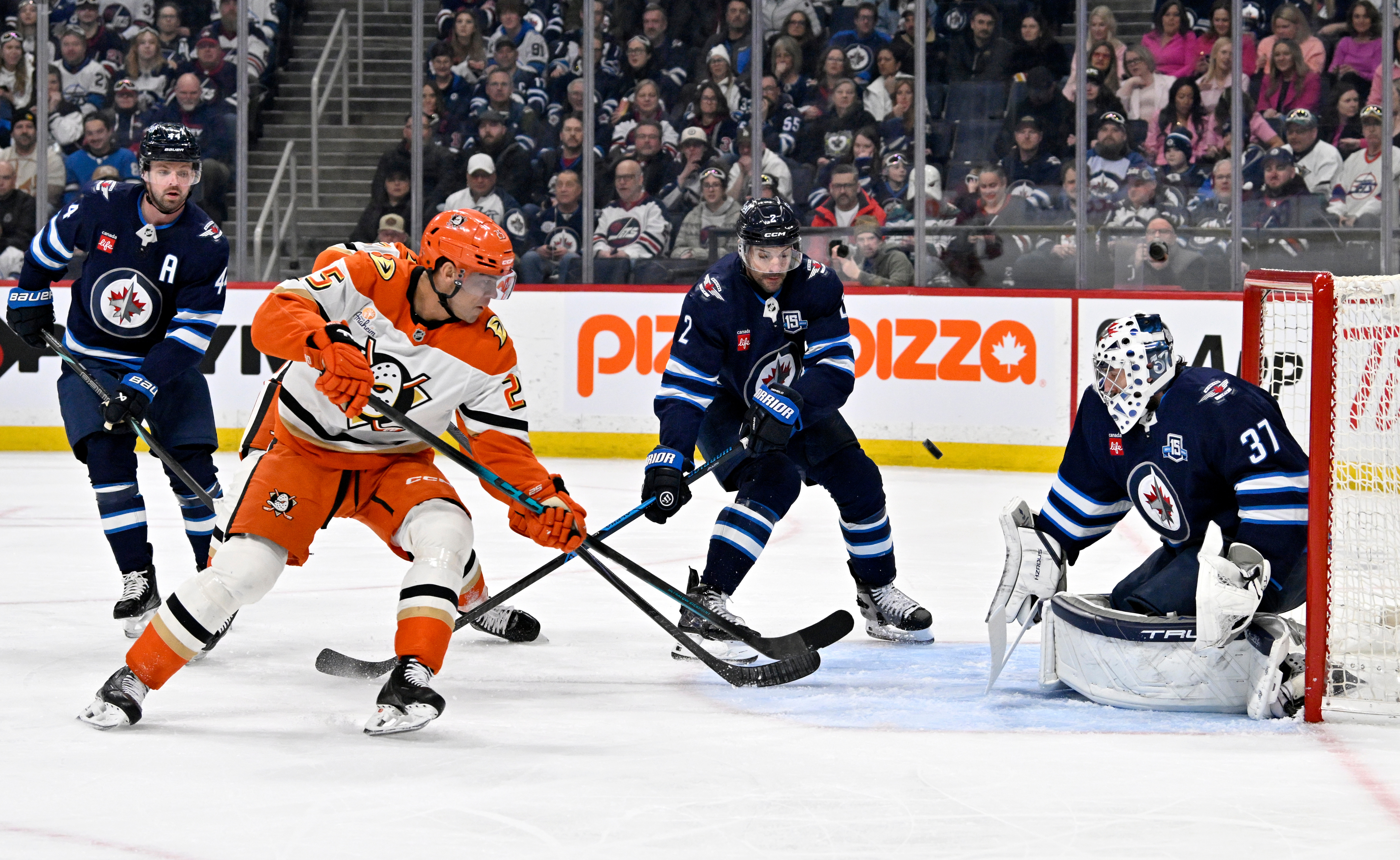 Winnipeg Jets goaltender Connor Hellebuyck, right, makes a save on...