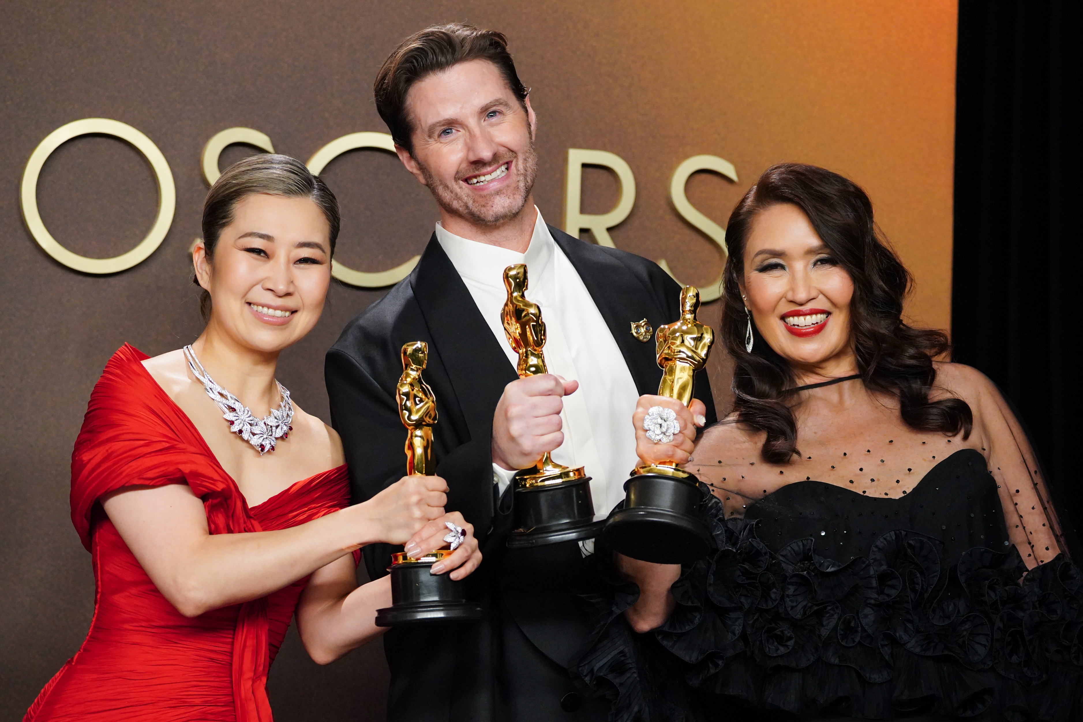 Maggie Kang, from left, Chris Appelhans, and Michelle L.M. Wong, winners of the award for animated feature film for “K-pop Demon Hunters,” pose in the press room at the Oscars on Sunday, March 15, 2026, at the Dolby Theatre in Los Angeles. (Photo by Jordan Strauss/Invision/AP)