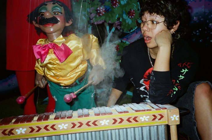 a puppeteer next to a puppet depicting a marimba player