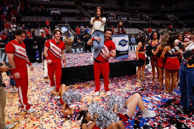 Arizona Wildcats cheerleaders celebrate by taking pictures with the confetti after Arizona Wildcats win against Purdue Boilermakers during the NCAA Tournament West Regional final at the SAP Center in San Jose, Calif., on Saturday, March 28, 2026.  (Shae Hammond/Bay Area News Group)