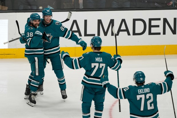 San Jose Sharks defenseman Shakir Mukhamadullin, second from left, is congratulated by defenseman Mario Ferraro (38), center Michael Misa (77) and left wing William Eklund (72) after scoring against the Edmonton Oilers during the third period of an NHL hockey game in San Jose, Calif., Saturday, Feb. 28, 2026. (AP Photo/Jeff Chiu)