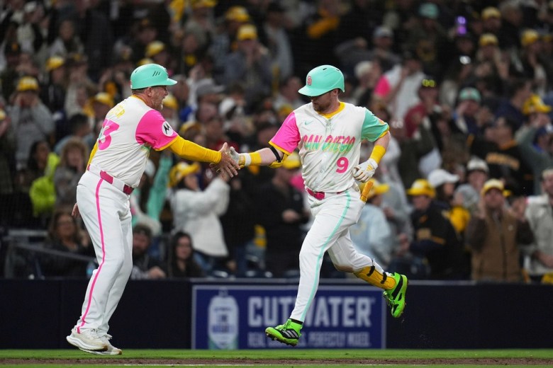 San Diego Padres' Jake Cronenworth celebrates with third base coach Tim Leiper