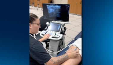 A student performs an ultrasound scan on a research participant's hamstring.