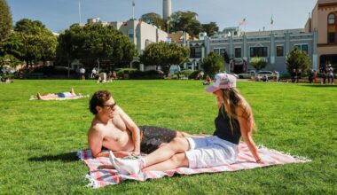 Nick Gardetto, left, and Madi Hirsch lounge in the sun at Washington Square during a heat wave in San Francisco on Sunday.
