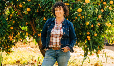 Woman stands in front of tree