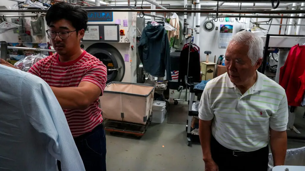 Enoch Ku and his father, Ha Wan Ku, working together at Vogue Cleaners, their family business. Photo by Denis Akbari.