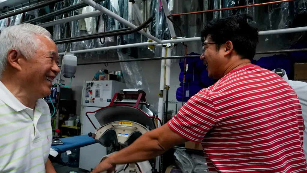 Ha Wan Ku and his son Enoch Ku working together at Vogue Cleaners, their family business. Photo by Denis Akbari.