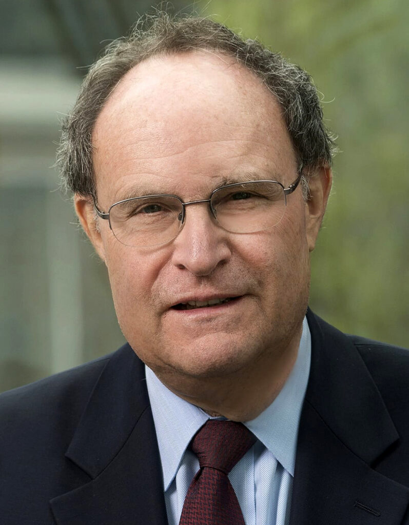headshot of David B. Oppenheimer, in a dark blue jacket, light blue shirt and burgundy tie