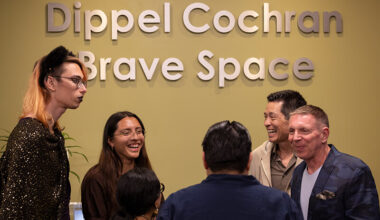 Students, staff and community supporters talk in front of the Dippel Cochran Brave Space sign
