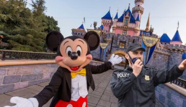Mickey Mouse in front of Sleeping Beauty Castle in Disneyland with a Police officer next to him as guests go through the gates thanks to the new facial recognition technology involved in a Disney incident.