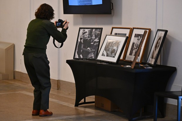 Visual Information Specialist Kimberly Twardochleb with the Juan Bautista de Anza National Historic Trail stops to take a photo of framed photographs of Betty Reid Soskin during a public celebration honoring the life and legacy of Betty Reid Soskin held at Calvin Simmons Theatre in Oakland, Calif., on Sunday, March 1, 2026. Soskin passed away last year at the age of 104 and was known for being the oldest National Park Service ranger assigned to the Rosie the Riveter World War II Home Front National Historical Park in Richmond. (Jose Carlos Fajardo/Bay Area News Group)
