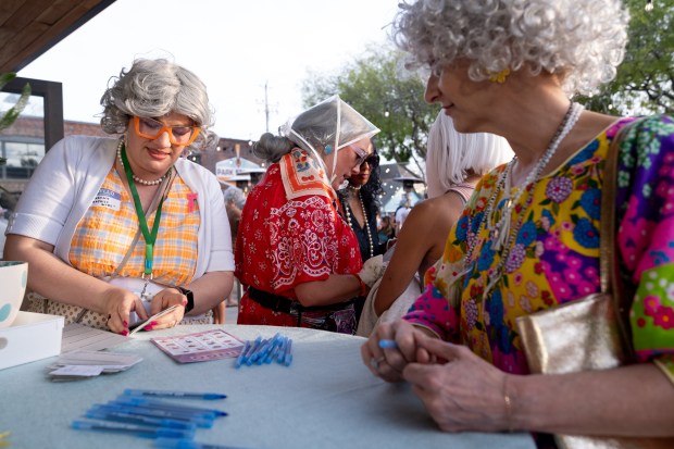 "Granny Graphics Guru" (left) helps an attendee at Park Station during the GrannyCon 2026 Afterparty event in Alameda, Calif., Saturday, March 07, 2026. The lighthearted event is a fundraiser for breast cancer research, education and legislation. GrannyCon was formed by a group of moms during the Coronavirus Pandemic of 2020. (Douglas Despres / for the Bay Area News Group)