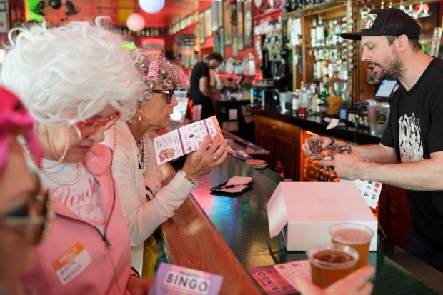 Kris Gordon serves alcohol to a group of grannies inside the Lucky 13 bar on Park Street during the 2nd Annual GrannyCon in Alameda, Calif., Saturday, March 07, 2026. The lighthearted event is a fundraiser for breast cancer research, education and legislation. It was formed by a group of moms during the Coronavirus Pandemic of 2020. (Douglas Despres / for the Bay Area News Group)