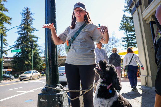 Alex Chung, with her dog Mia, shares her point of view on the City of Oakland's proposal to build new housing units near the Rockridge BART station in Oakland, Calif., on Friday, March 6, 2026. A new California housing law allows homes to be built near public transit hubs. (Ray Chavez/Bay Area News Group)