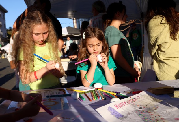 Sisters Hazel, 10, and Violet, 5, Mosalli, of San Ramon, decorate eggs during the Persian New Year Festival on Durant Avenue in Berkeley, Calif., on Tuesday, March 17, 2026. (Jane Tyska/Bay Area News Group)