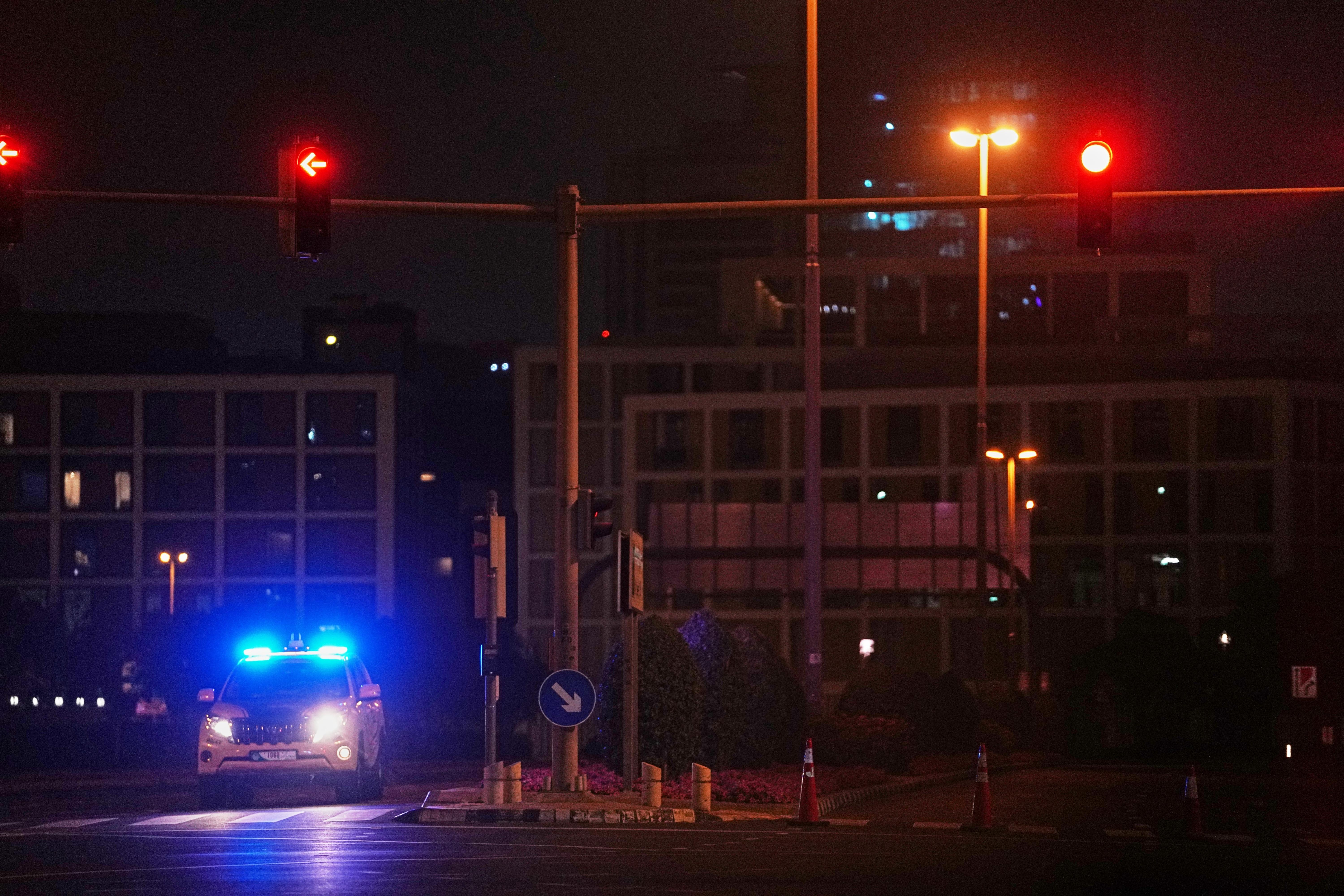 A police car blocks a street leading to the U.S. consulate after an Iranian drone struck.