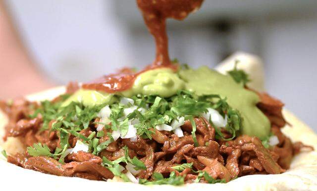 Salsa is added to an al pastor burrito from Tacos El Cabezon, a food truck parked at the corner of Shaw and Marks avenues. Photographed Wednesday, Sept. 24, 2025 in Fresno.