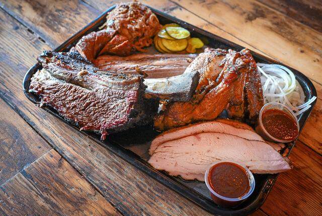 Various barbecue meats including a large beef rib, pork ribs, pulled pork, chicken, hot link and turkey breast sit on a platter at Horn Barbecue which opened in Fresno's Granite Park on Jan. 20, 2026.