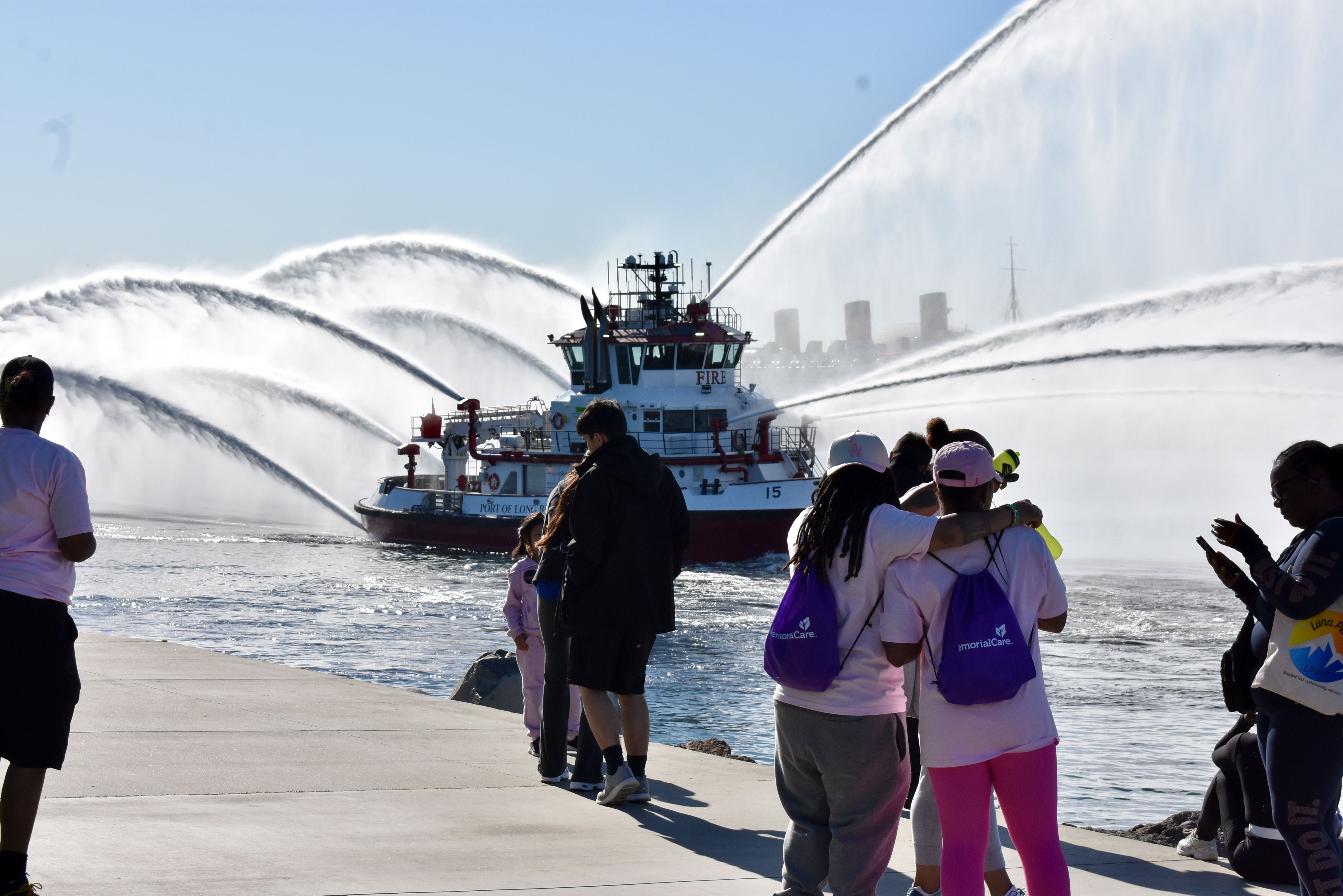 Spectators pause along the waterfront to watch the Long Beach...