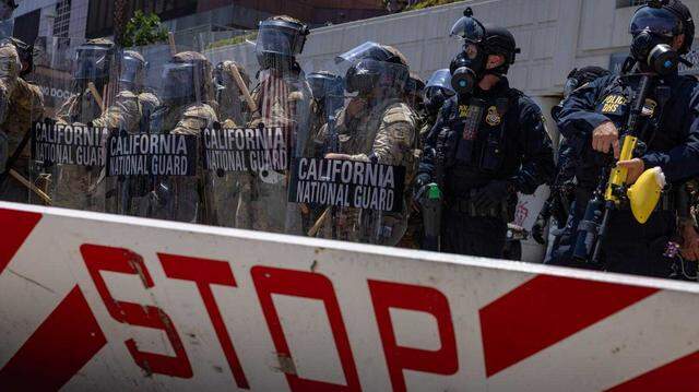 California National Guard troops stand outside the Metropolitan Detention Center in downtown Los Angeles on Sunday amid protests against federal immigration raids. The troop presence followed President Donald Trump’s directive to send 4,000 Guard members and 700 Marines to the city over the objections of Gov. Gavin Newsom, who has challenged the legality of the deployment in federal court. California National Guard troops stand outside the Metropolitan Detention Center in downtown Los Angeles on Sunday amid protests against federal immigration raids. The troop presence followed President Donald Trump’s directive to send 4,000 Guard members and 700 Marines to the city over the objections of Gov. Gavin Newsom, who has challenged the legality of the deployment in federal court.