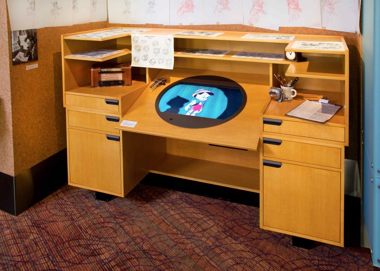 A photo of the animator's desk with a Pinnochio cartoon playing on a small television.