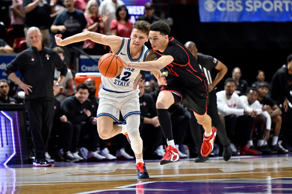 Mason Falslev #12 of the Utah State Aggies and Miles Byrd #21 of the San Diego State Aztecs battle for the ball during the Mountain West championship game on March 14, 2026.