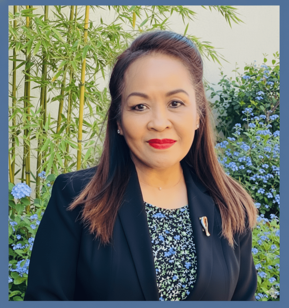A portrait of a woman with brown hair in front of bamboo shoots.