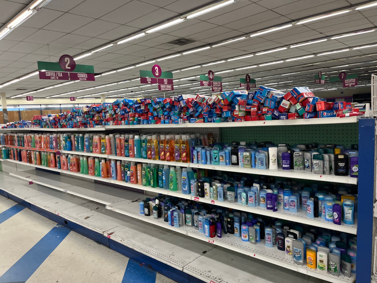 An aisle in the converted 99 Cent Store with shelves full of toothpaste, body wash, deodorant, and other hygiene products.