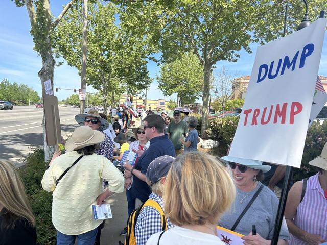 Protesters with the “No Kings” rally against the Trump administration gather on the sidewalk Saturday afternoon near the Lincoln Crossing Marketplace shopping center in Lincoln.