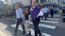 Allen Mutchler (right) marches on Fifth Avenue with his husband and their young daughter. There were one of the families participating in a Palm Sunday processions, March 29, 2026.