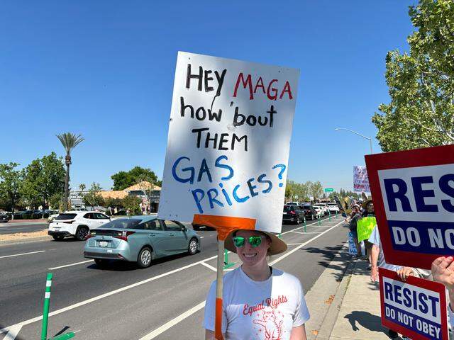 Protester holds sign about gas prices at Fresno’s “No Kings” protest near on Blackstone Avenue near River Park on Saturday March 28, 2026.
