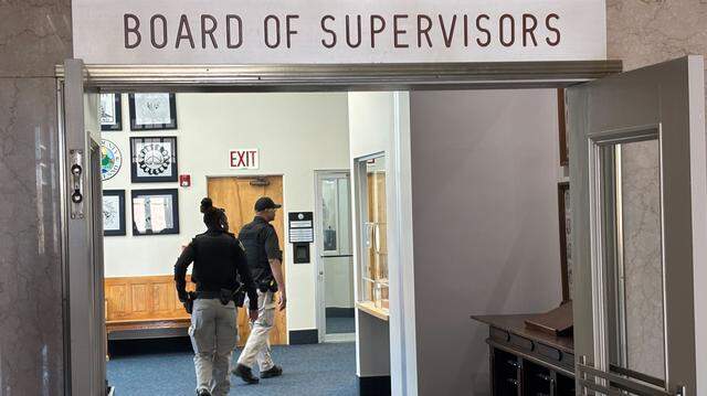 Security guards enter the lobby outside the Fresno County Board of Supervisors chamber in the Hall of Records in Fresno on Monday, March 23, 2026.