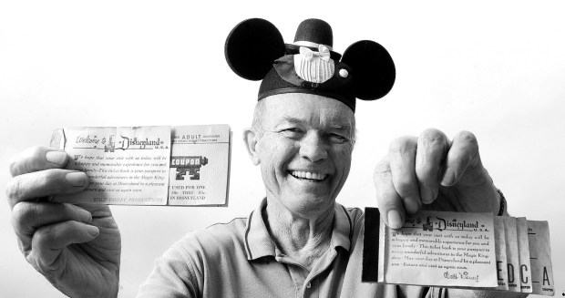Paul Cuthbert, who participated in Disneyland's opening day parade as an Eagle Scout, displays old ride ticket books from 1955. (Mindy Schauer, Orange County Register)