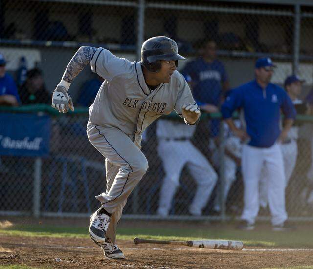 Elk Grove High School’s Derek Hill singles in the eighth inning in the high school baseball game between Davis and Elk Grove in Davis on May 6, 2014.
