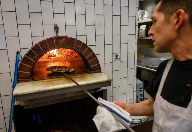 Bobby Masullo, owner of Masullo Pizza, takes the "Eileen" out of the oven at his restaurant in Land Park in Sacramento on Jan. 23, 2020. Named after Masullo's mother who loves bacon, the Eileen is a pizza with mozzarella, crimini mushrooms, bacon, cream, sage and black pepper.