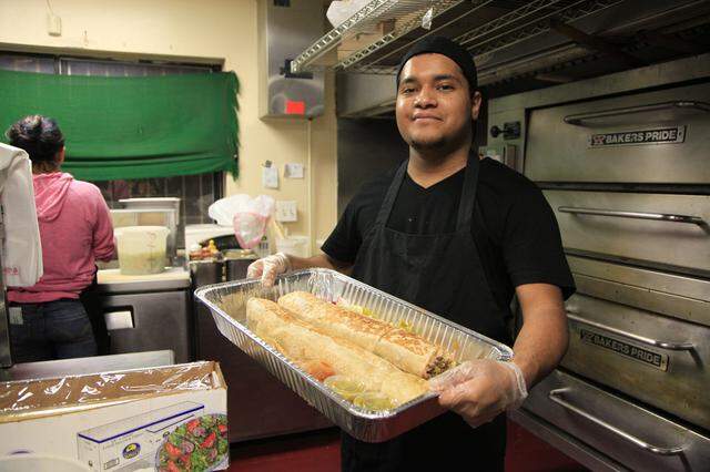 Edwin Espinoza of Taqueria Yarelis, a Fresno taqueria, holds an Anaconda burrito. The whopper of a burrito is 3 feet long.
